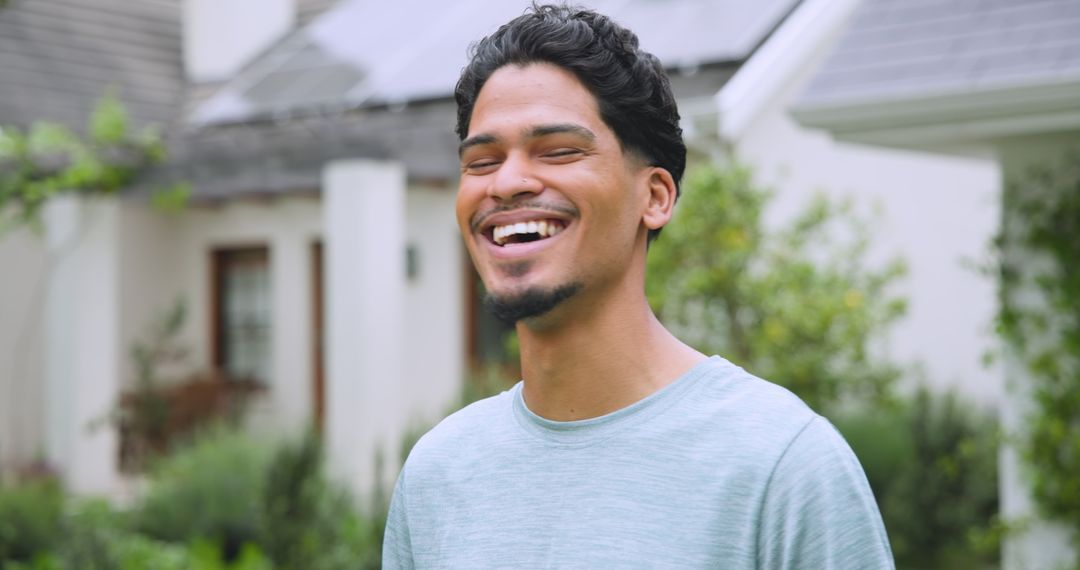 Smiling Man Posed by Eco-Friendly Solar Panel Home