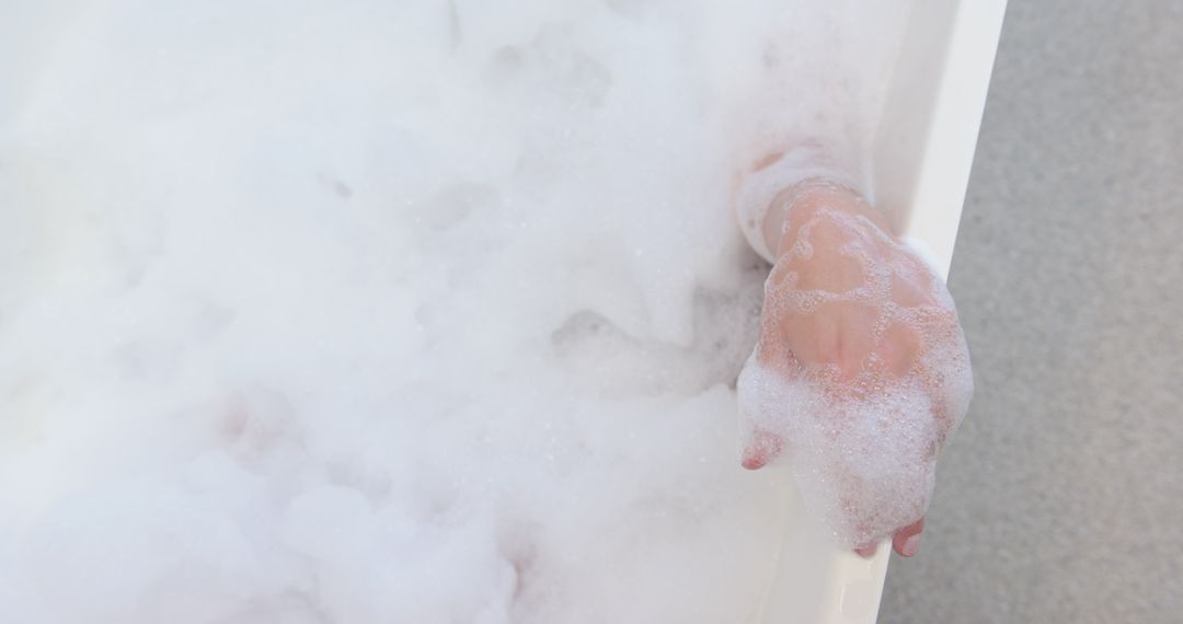 Woman's Forearm Resting on Bathtub Edge with Foam