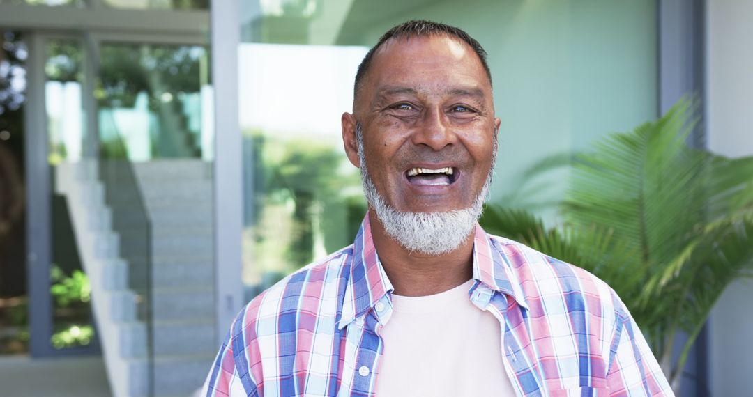 Mature Man Radiating Happiness in Plaid Shirt Outdoors