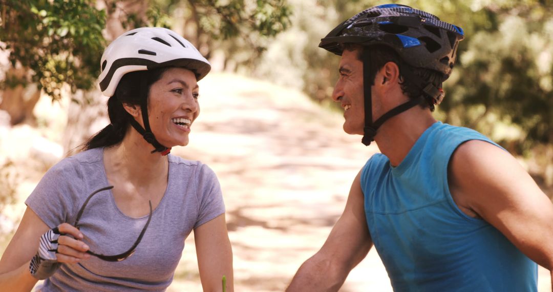 Smiling young couple riding bicycle in forest - Free Images, Stock Photos and Pictures on Pikwizard.com