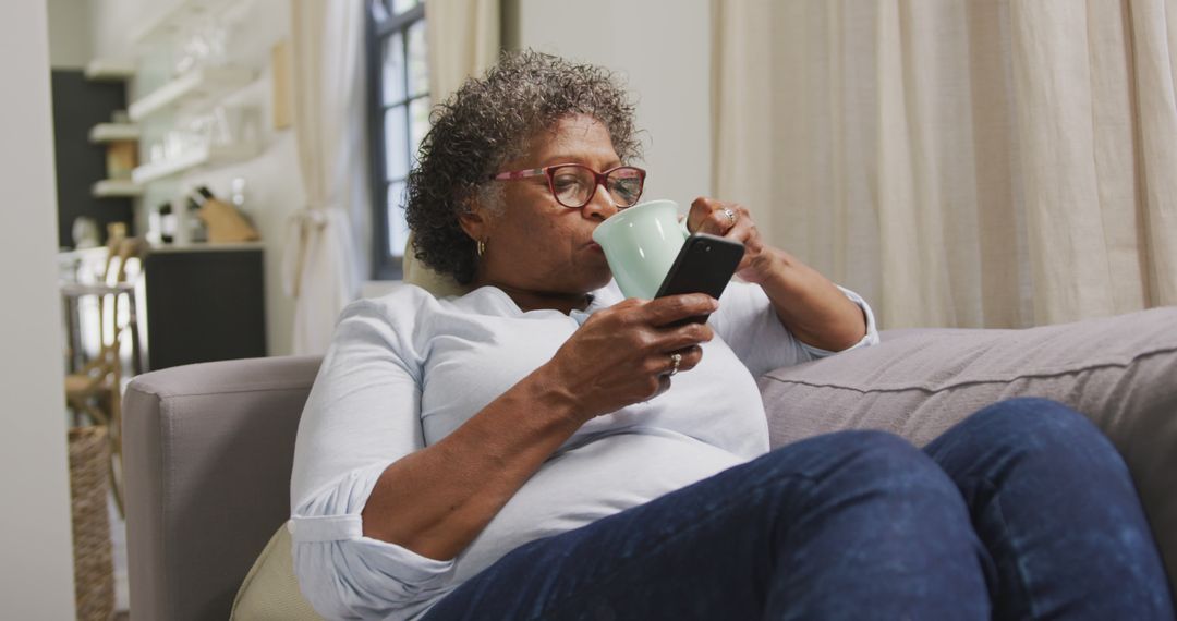 Senior Woman Relaxing at Home with Coffee and Smartphone - Free Images, Stock Photos and Pictures on Pikwizard.com