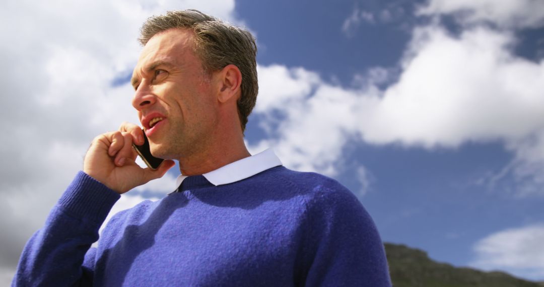 Businessman Talking on Smartphone Outdoors on a Cloudy Day - Free Images, Stock Photos and Pictures on Pikwizard.com