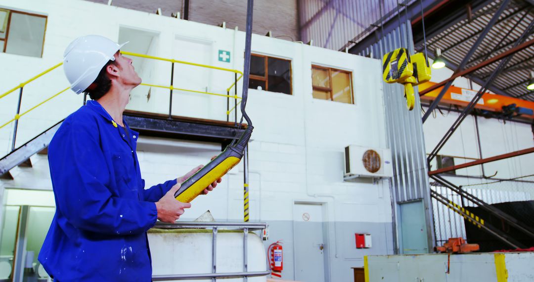 Engineer Operating Hoist Machine in Industrial Workshop - Free Images, Stock Photos and Pictures on Pikwizard.com