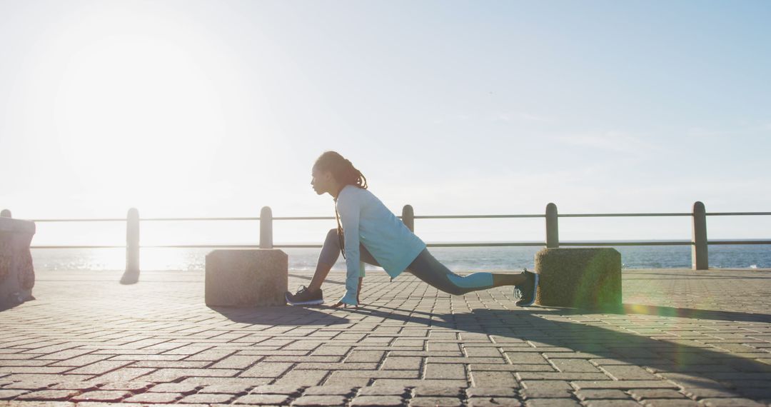 Woman Stretching Outdoors at Seaside in Morning Sunlight - Free Images, Stock Photos and Pictures on Pikwizard.com