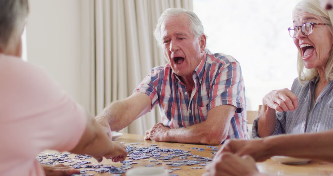 Senior Friends Enjoying Laughs While Solving Puzzle Together - Free Images, Stock Photos and Pictures on Pikwizard.com