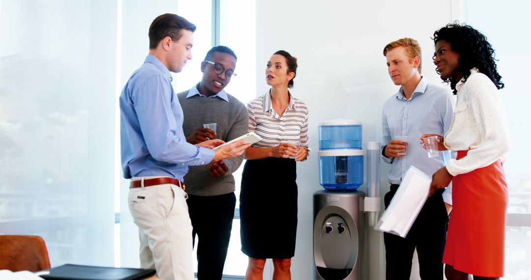 Diverse Professionals Having Collaborative Discussion Near Water Cooler