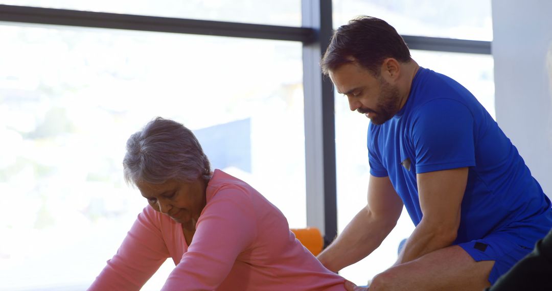 Physical Therapist Coaching Senior Woman on Stretching Exercise Near Large Window - Free Images, Stock Photos and Pictures on Pikwizard.com