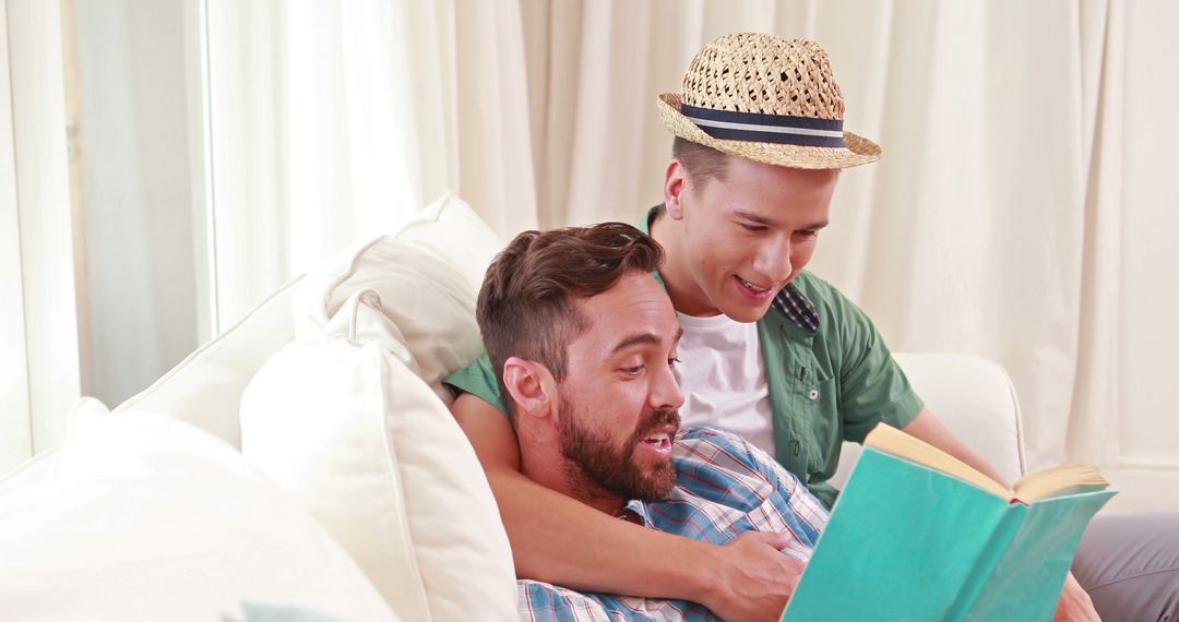 Father and Son Bonding with a Book on Couch