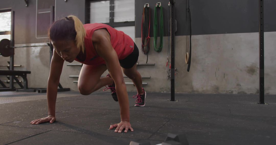 Woman Exercising with Mountain Climbers in Gym
