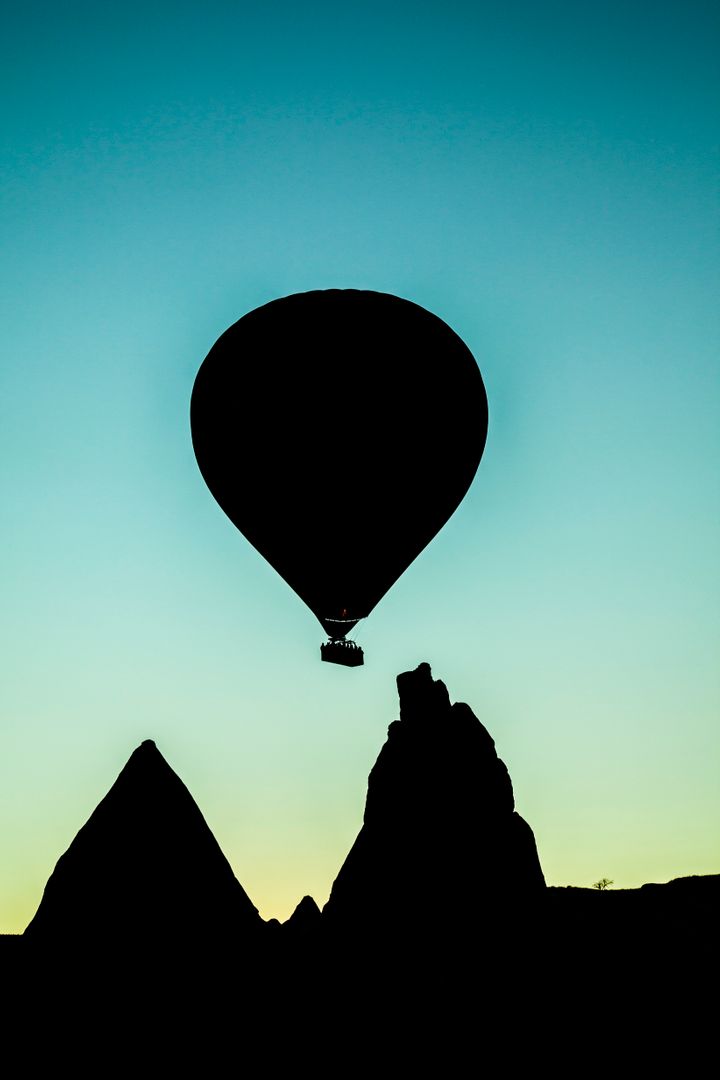 Hot Air Balloon Floating Over Unique Rock Formations During Sunset - Free Images, Stock Photos and Pictures on Pikwizard.com