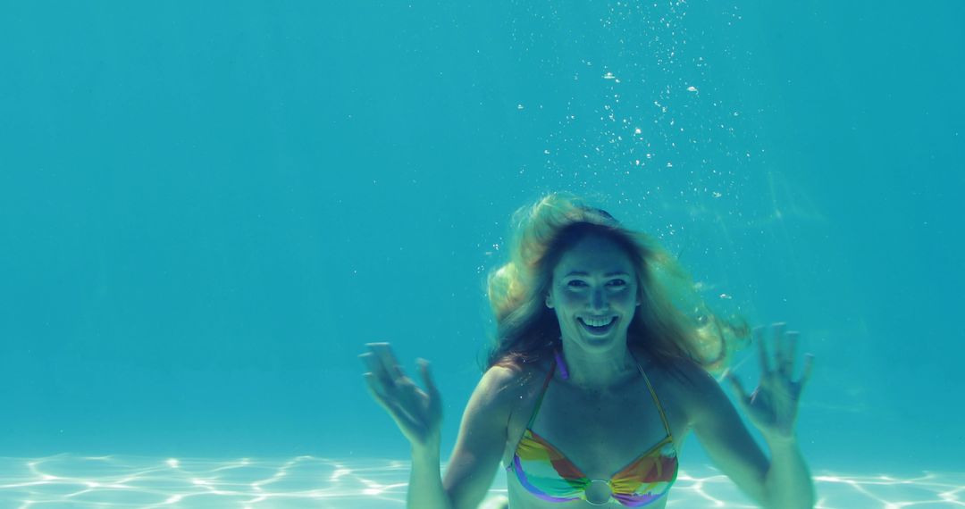 Woman in Colorful Bikini Swimming Underwater in Pool - Free Images, Stock Photos and Pictures on Pikwizard.com