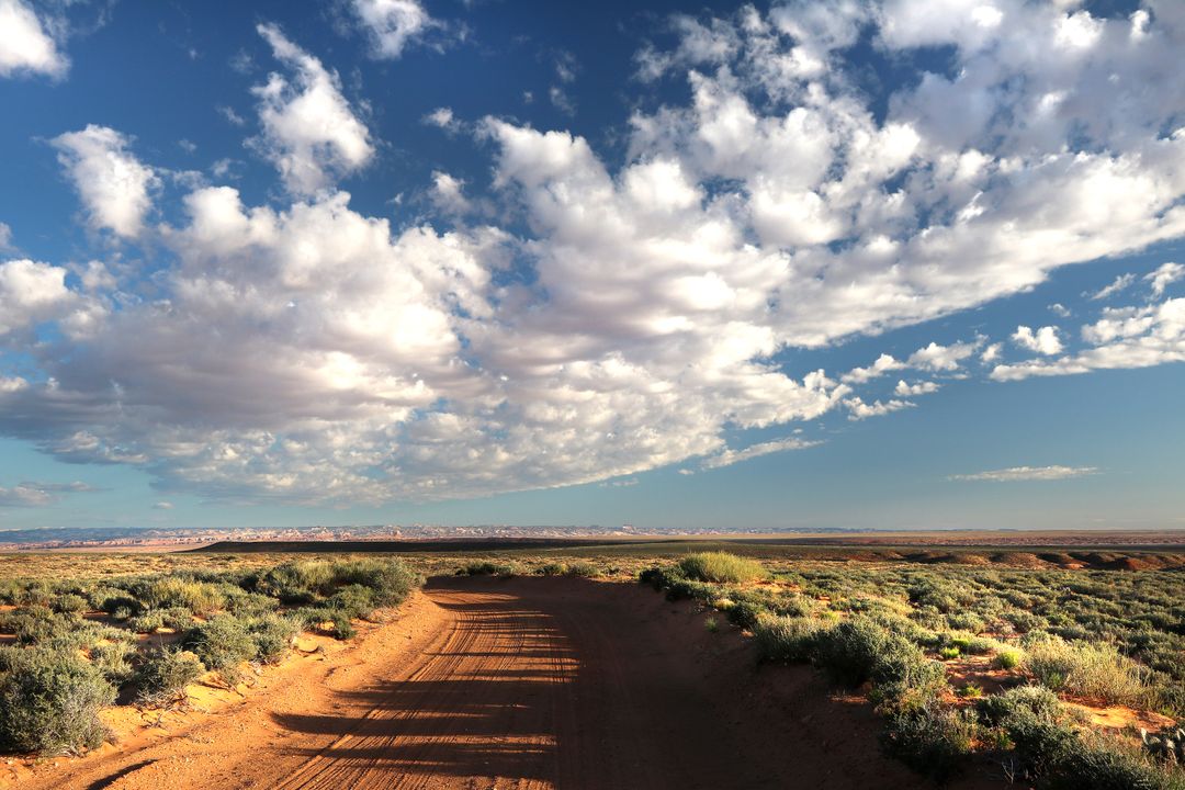 Dirt Road and Expansive Sky in a Vast Desert Landscape - Free Images, Stock Photos and Pictures on Pikwizard.com