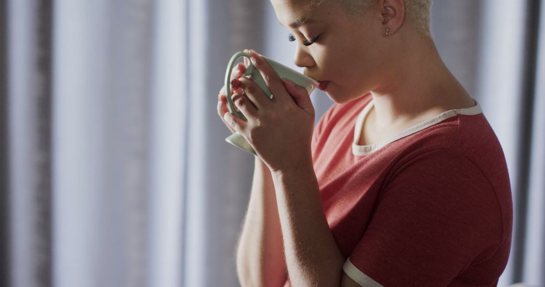 Young African American Woman Sipping Hot Beverage in Morning Light - Free Images, Stock Photos and Pictures on Pikwizard.com