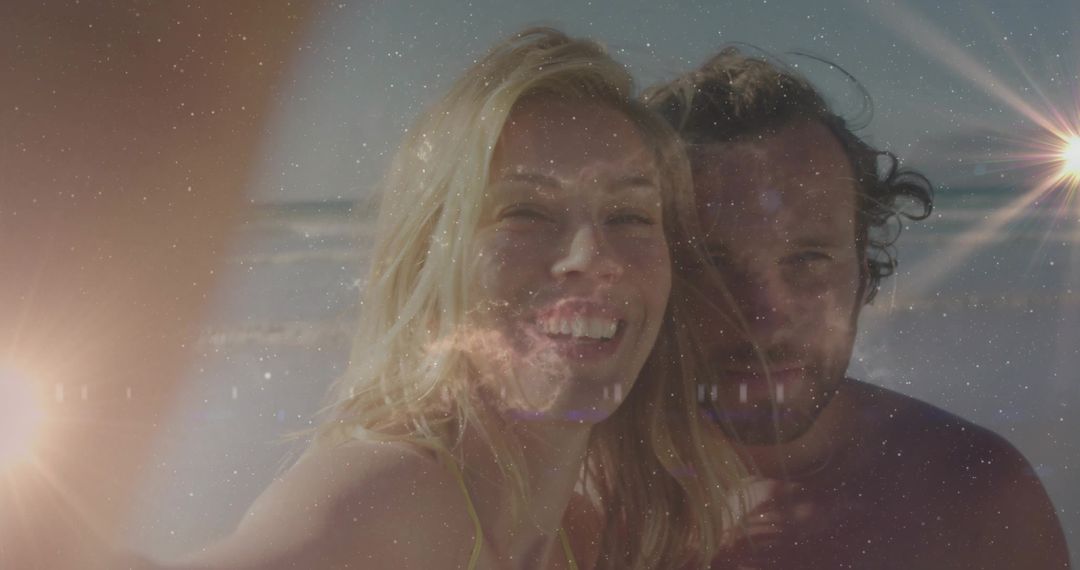 Couple Enjoying Sunny Beachfront Selfie with Vibrant Lens Flare