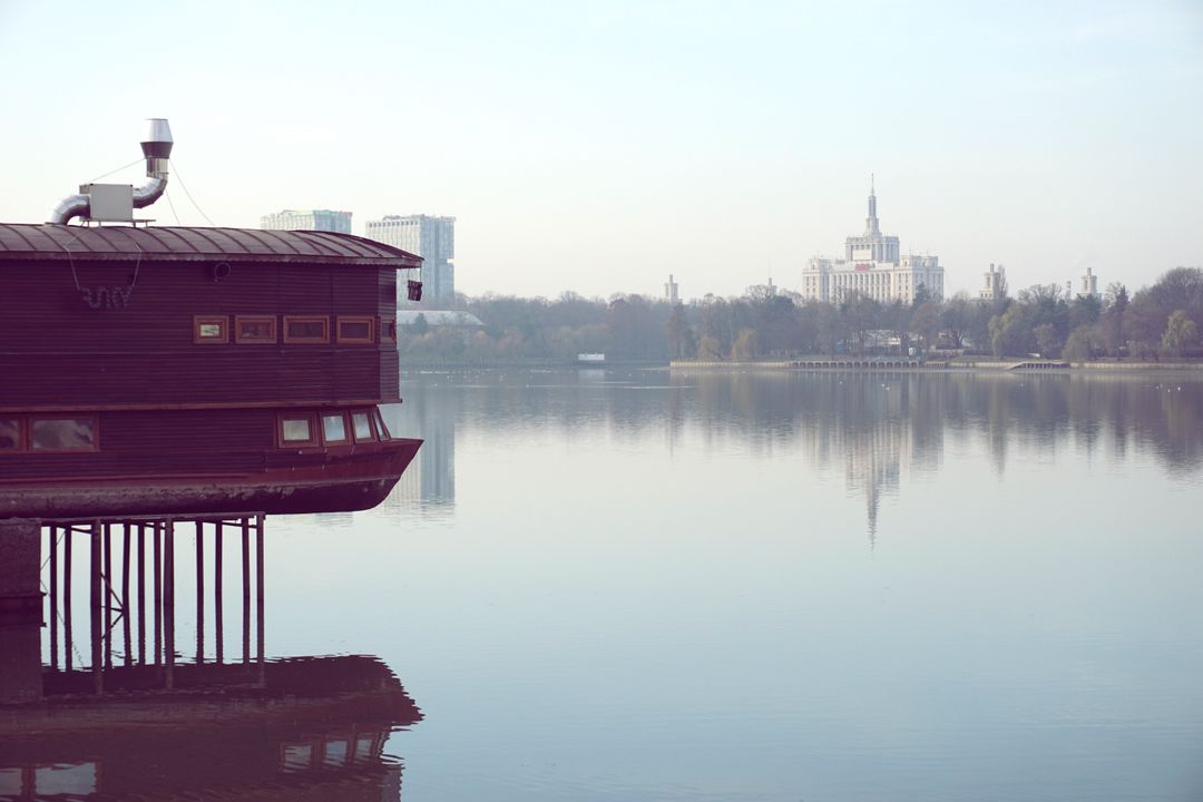 Serene Lakeside Cabin with City Skyline - Free Images, Stock Photos and Pictures on Pikwizard.com