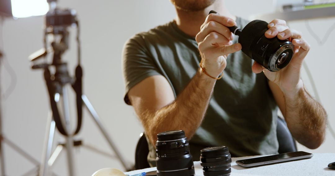 Professional Photographer Adjusting Camera Lens in Studio - Free Images, Stock Photos and Pictures on Pikwizard.com