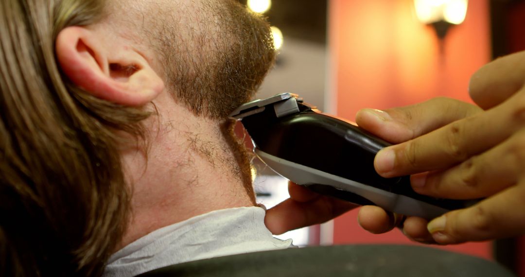 A Caucasian man is getting a haircut with an electric trimmer, with copy space - Free Images, Stock Photos and Pictures on Pikwizard.com