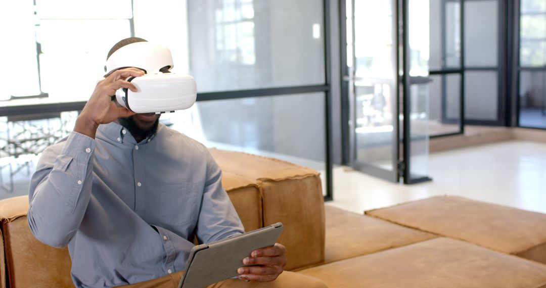 Man in VR Headset Using Tablet in Modern Office