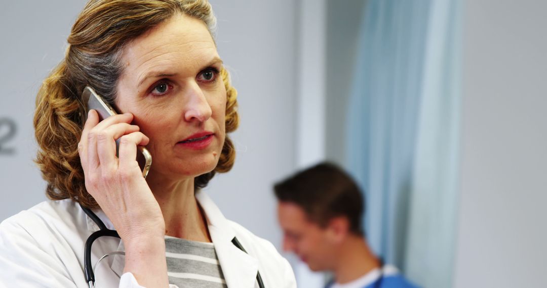 Professional Female Doctor Talking on Phone in Hospital Ward - Free Images, Stock Photos and Pictures on Pikwizard.com