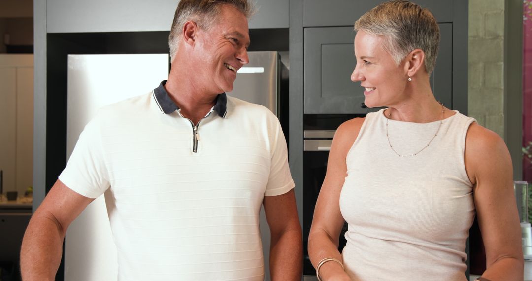 Smiling Middle-Aged Couple in Modern Kitchen Setting