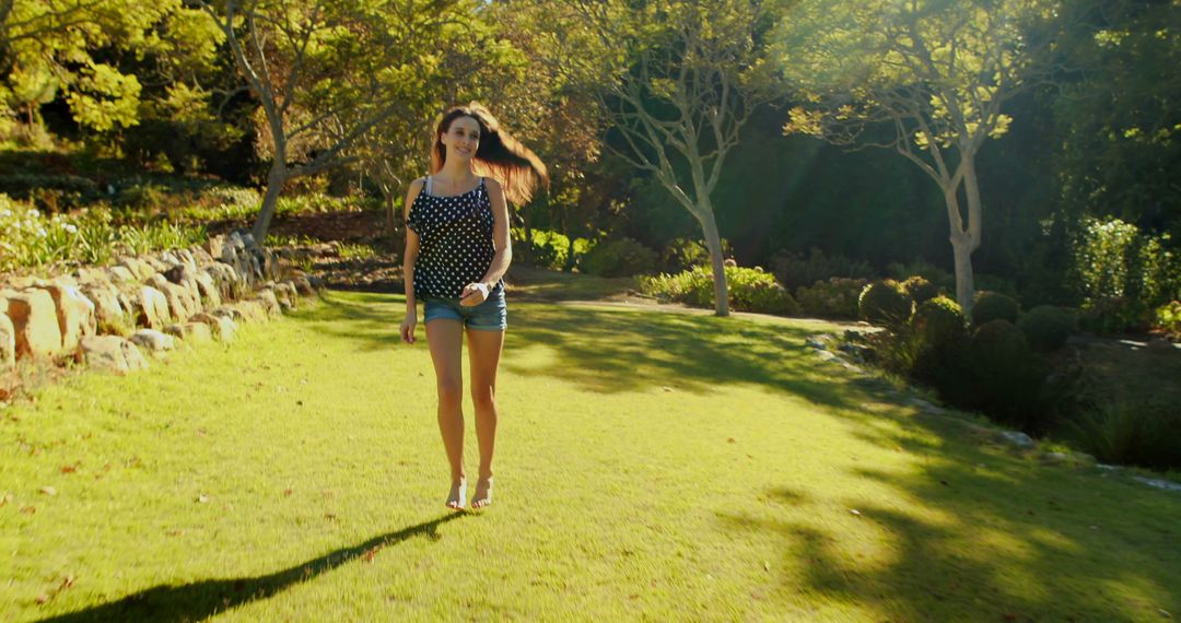 Young Woman Strolling in Sunny Park - Free Images, Stock Photos and Pictures on Pikwizard.com