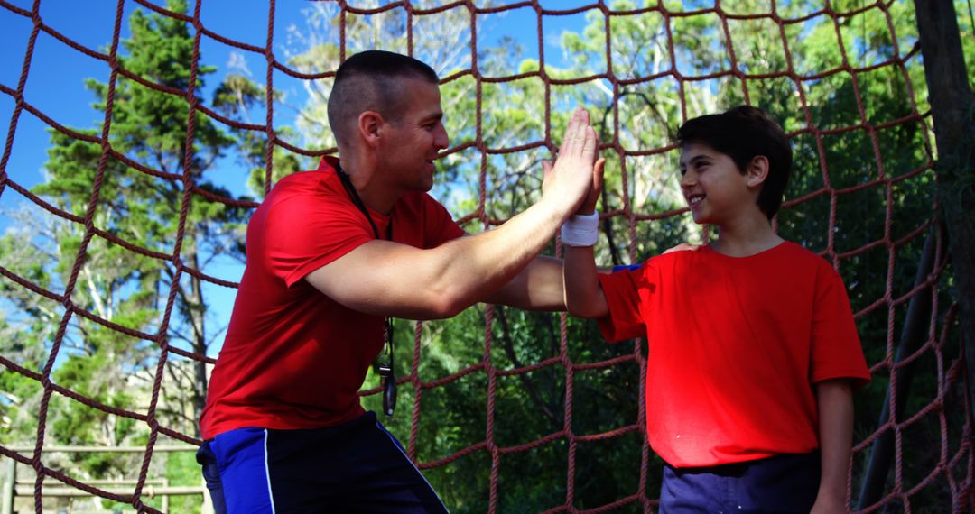 Coach Encouraging Young Boy During Outdoor Obstacle Course - Free Images, Stock Photos and Pictures on Pikwizard.com