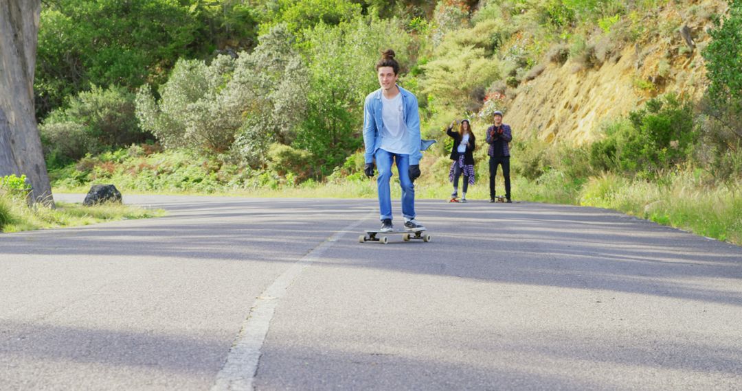 Young Adult Skateboarding on Scenic Forest Road - Free Images, Stock Photos and Pictures on Pikwizard.com