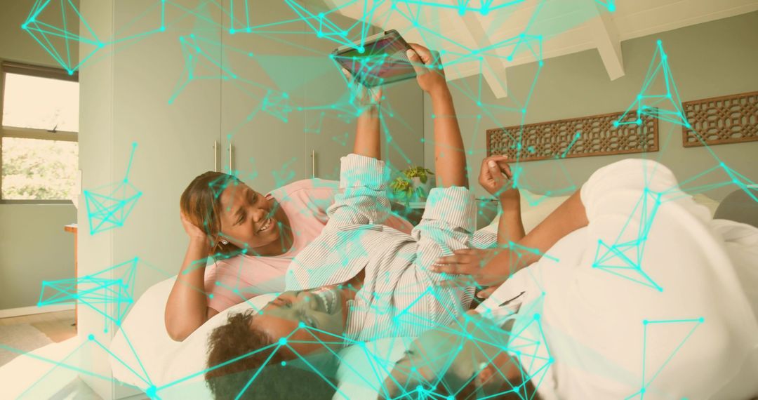 Three Black women lounging on bed laughing and sharing smartphone with teal web overlay