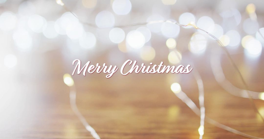 Merry Christmas Message with Festive Lights on Wooden Surface