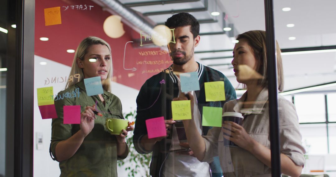 Creative Team Brainstorming Ideas with Sticky Notes on Office Glass Wall - Free Images, Stock Photos and Pictures on Pikwizard.com