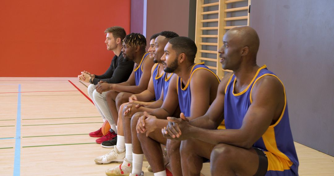 Diverse Basketball Team Sitting on Bench at Indoor Gym