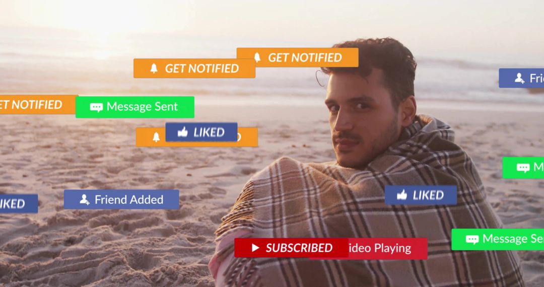 Man Wrapped in Blanket at Beach with Social Media Notifications