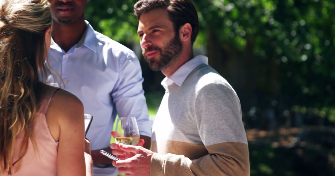 Smiling Friends Enjoying Conversation at Outdoor Gathering