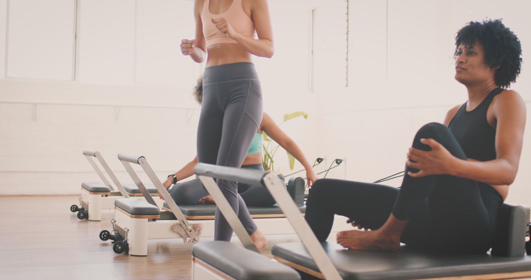 Diverse Women Practicing Pilates on Reformer Machines