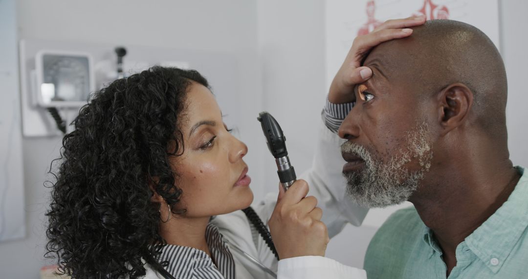 Biracial female doctor examining eye of diverse senior male patient in hospital with ophthalmoscope - Free Images, Stock Photos and Pictures on Pikwizard.com