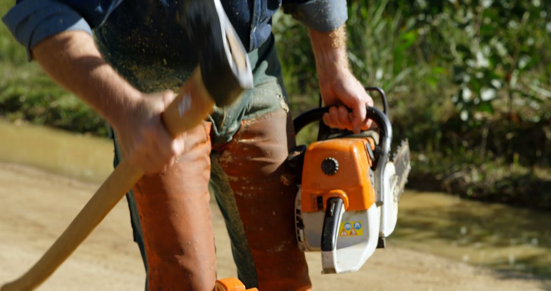 Lumberjack in Action with Chainsaw and Axe Outdoors - Free Images, Stock Photos and Pictures on Pikwizard.com