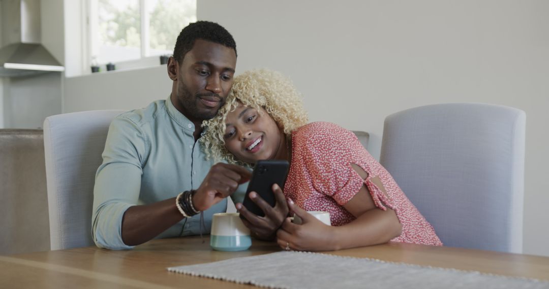 Happy Couple Bonding at Home While Using Smartphone