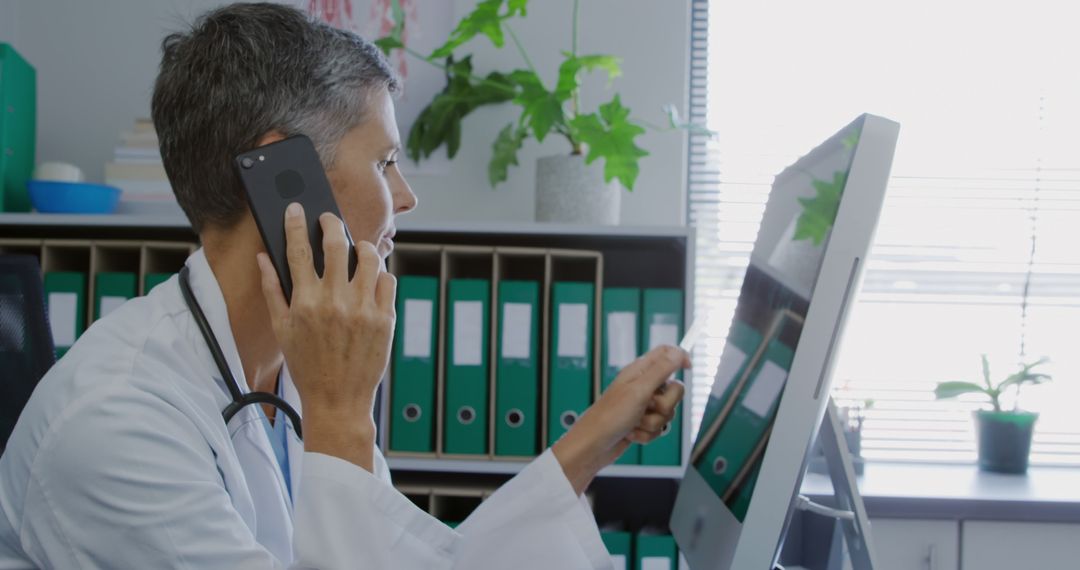 Female Doctor Using Phone and Computer in Medical Office - Free Images, Stock Photos and Pictures on Pikwizard.com