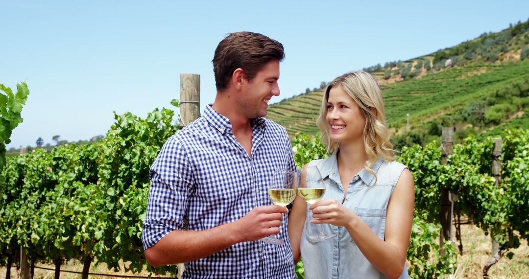 Happy Couple Enjoying Wine Tasting in Sunlit Vineyard