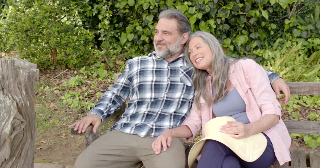Senior Couple Relaxing on Bench in Serene Garden with Lush Greenery