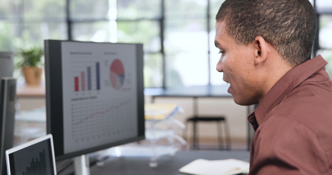 Businessman Analyzing Financial Data on Computer Monitor