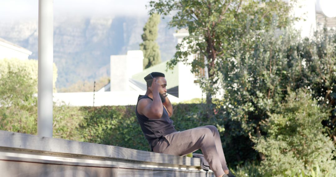 Man Exercising Outdoors Sitting on a Low Wall - Free Images, Stock Photos and Pictures on Pikwizard.com