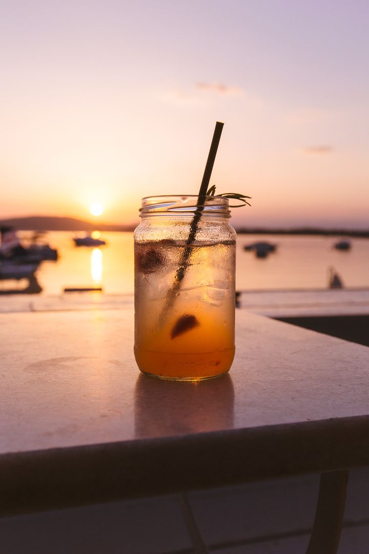 Iced Beverage with Straw in Jar at Sunset