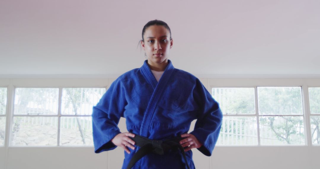 Confident Martial Artist Woman in Blue Gi Standing Firmly - Free Images, Stock Photos and Pictures on Pikwizard.com