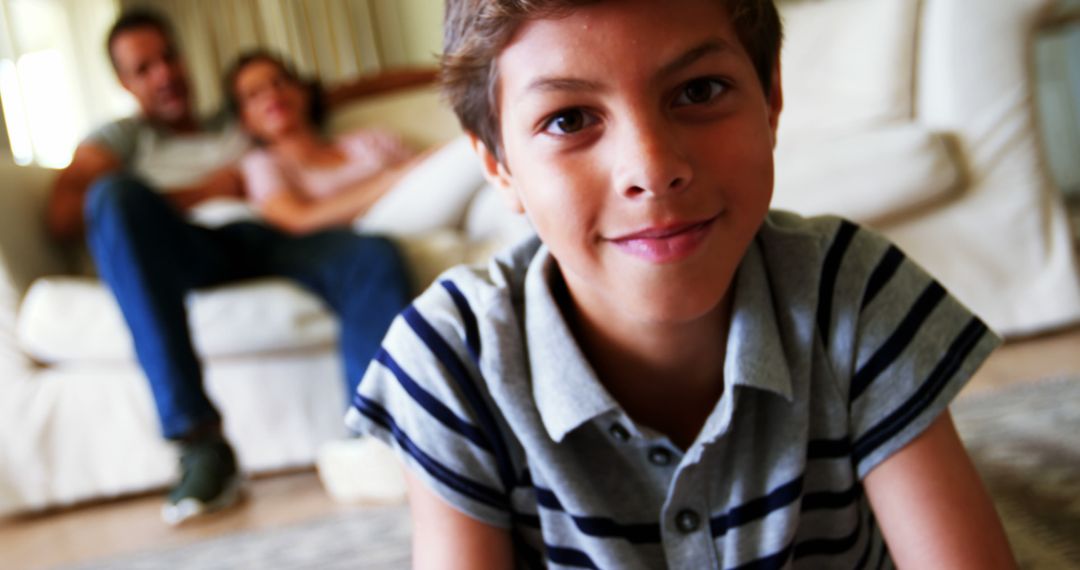 Smiling Boy Relaxing at Home with Family in Background - Free Images, Stock Photos and Pictures on Pikwizard.com