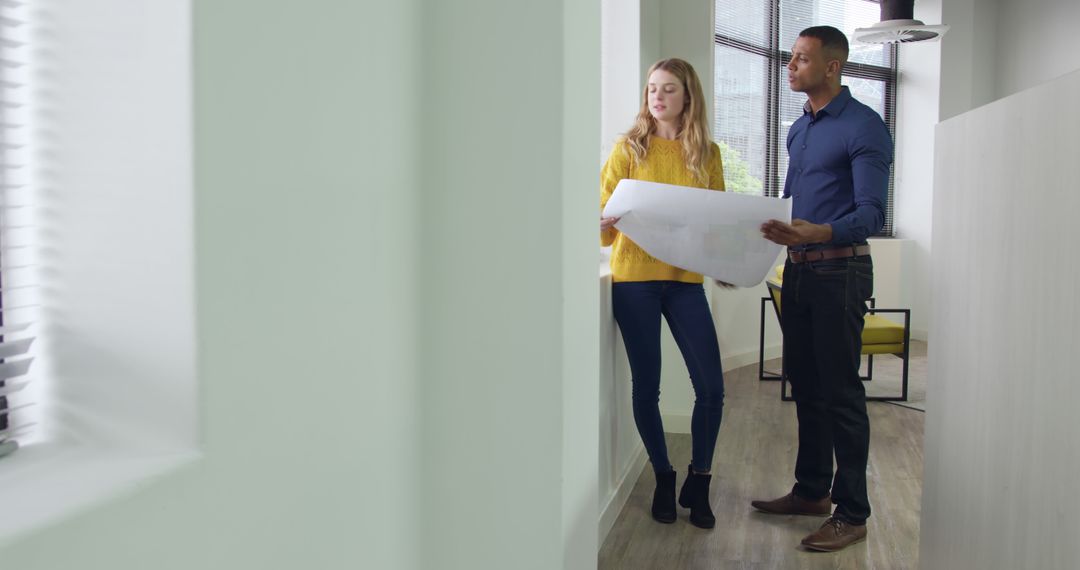 Team Collaborating on Design Plans in Modern Office Interior