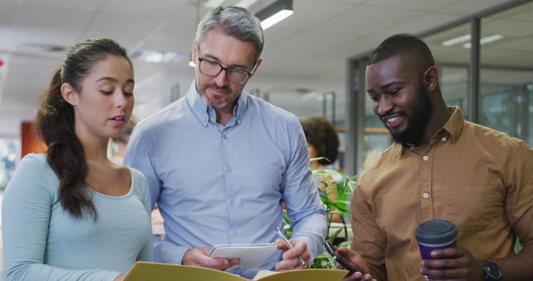 Diverse Colleagues Discussing Documents in Modern Office Environment