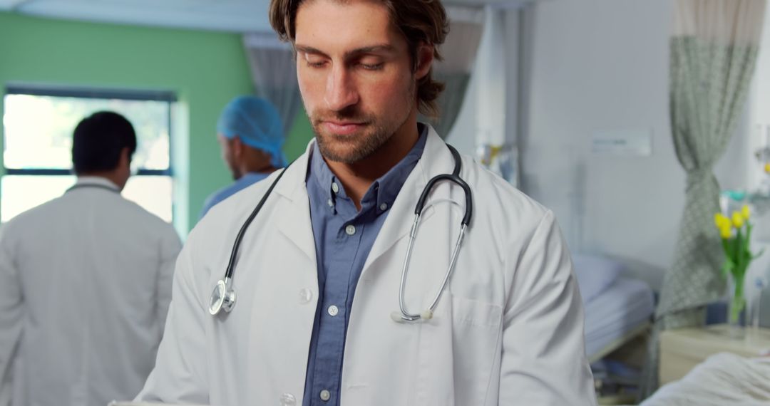 Young Male Doctor Wearing Lab Coat and Stethoscope in Hospital Room - Free Images, Stock Photos and Pictures on Pikwizard.com