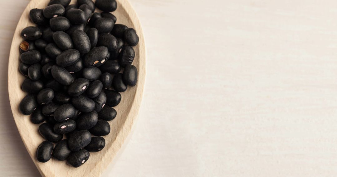High Angle View of Black Beans in Wooden Spoon on White Background
