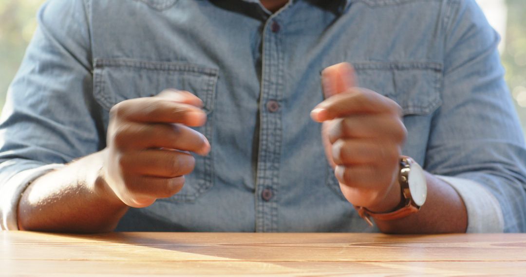Casual Conversation: Man Gesturing Expressively at Wooden Table